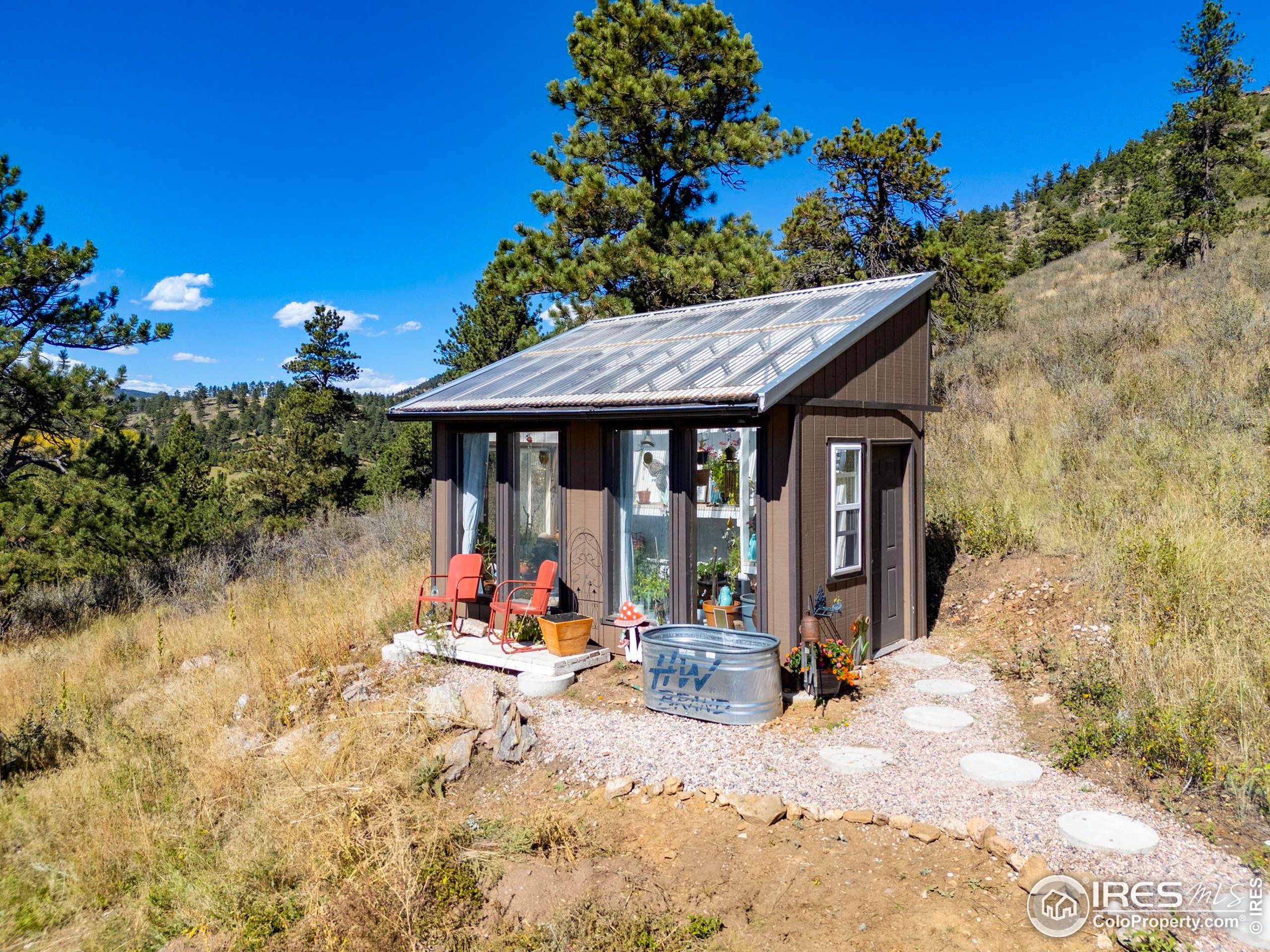 681 Bitterroot Gulch Road Loveland, CO 80537 - Photo 31 of 47 a view of a patio with a table and chairs under an umbrella