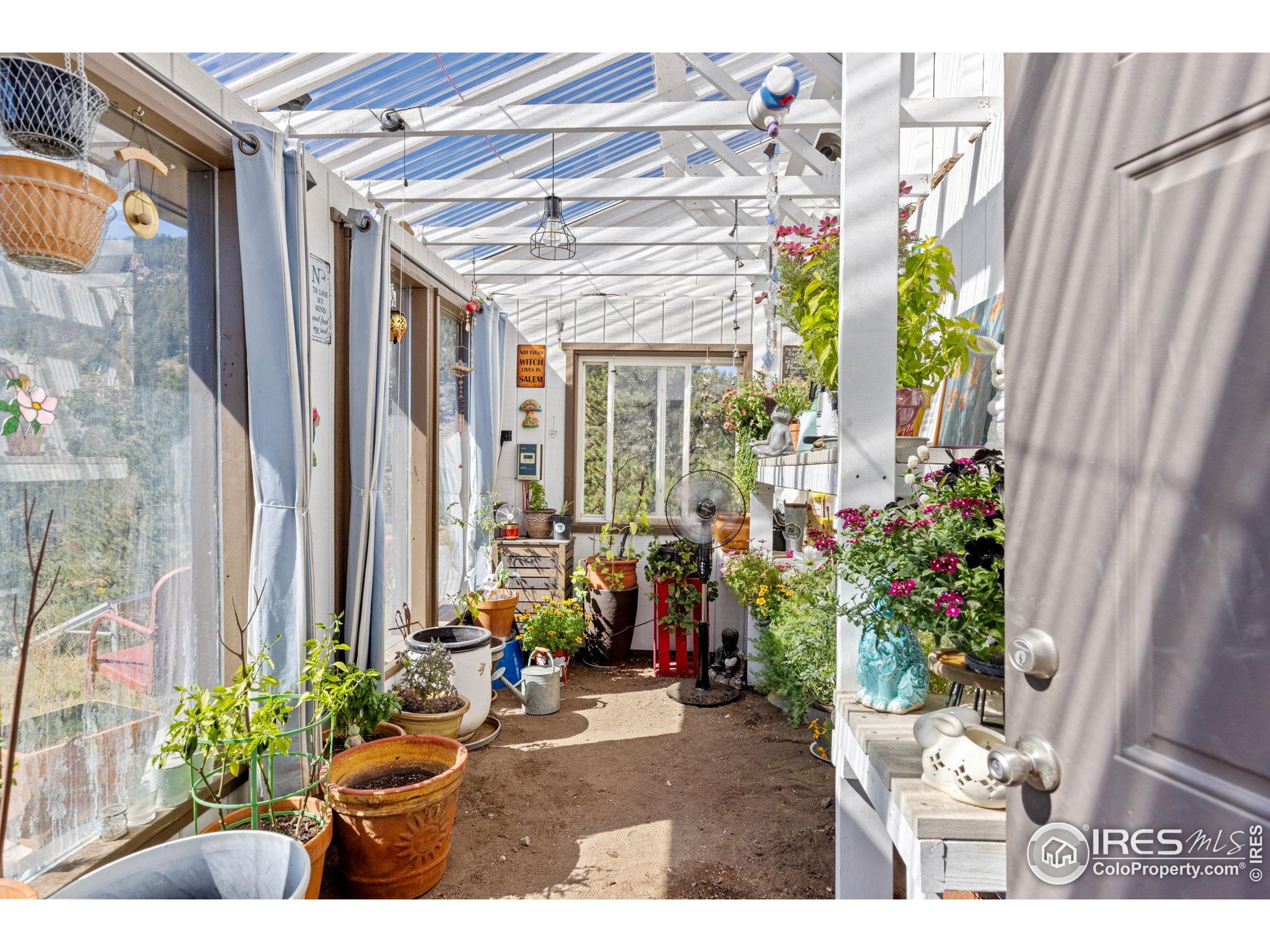 681 Bitterroot Gulch Road Loveland, CO 80537 - Photo 32 of 47 a view of a porch with chairs and potted plants