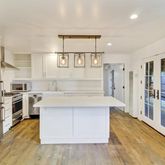 a large kitchen with stainless steel appliances a stove and refrigerator