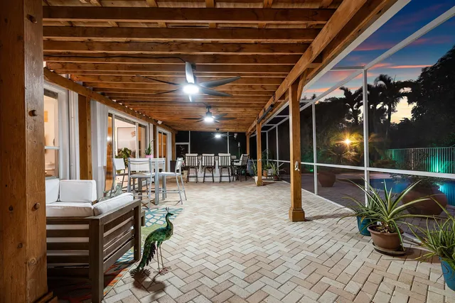a view of swimming pool with lounge chair and palm tree