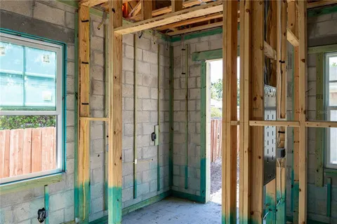 a view of an empty room with wooden floor and a chandelier
