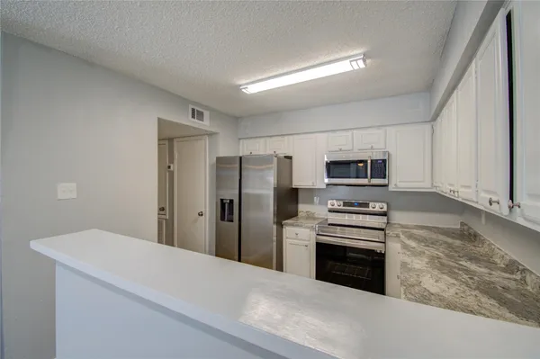 a kitchen with stainless steel appliances a refrigerator and a stove top oven