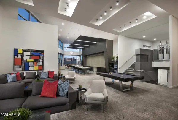 a living room with furniture kitchen view and a wooden floor