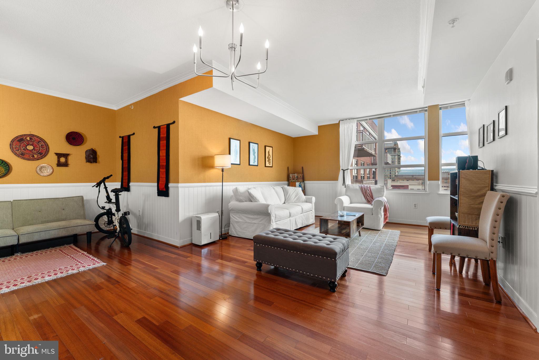 157 Fleet Street, Unit 1001 Oxon Hill, MD 20745 - Photo 6 of 24 a living room with furniture or couch and a dining table with wooden floor
