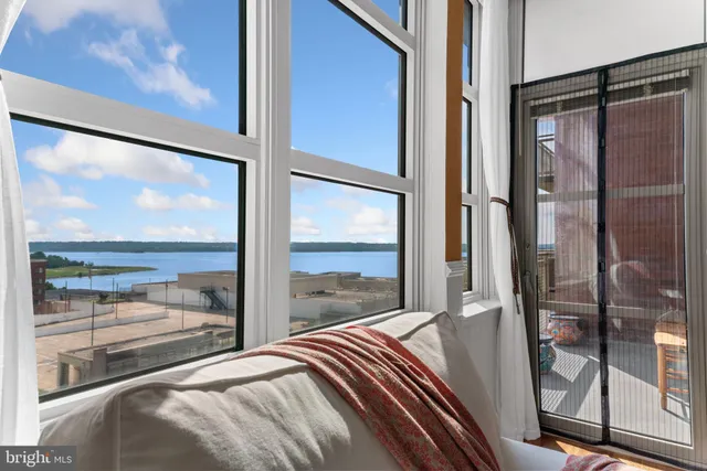 a bedroom with a large window and a bed