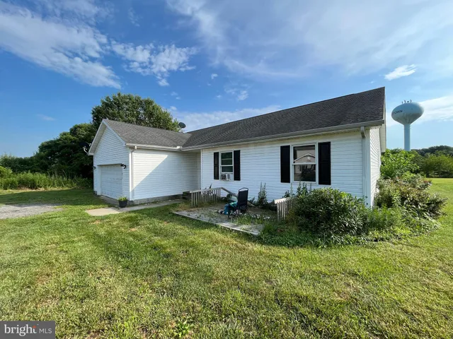 a view of backyard of house with green space