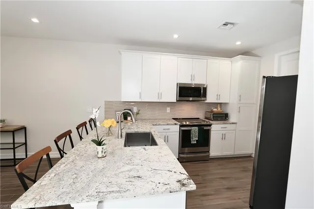 a kitchen with stainless steel appliances granite countertop a stove top oven a sink and a granite counter tops