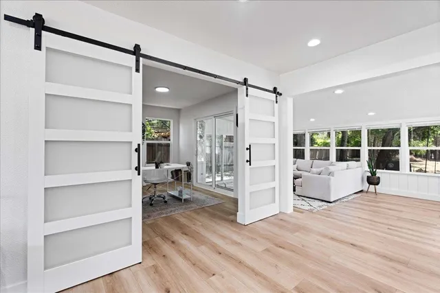 a view of a living room a ceiling fan and windows