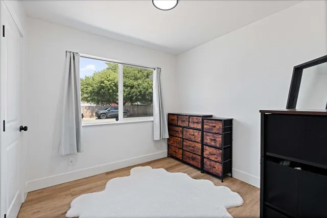a bedroom with a bed and a flat tv screen on the dresser