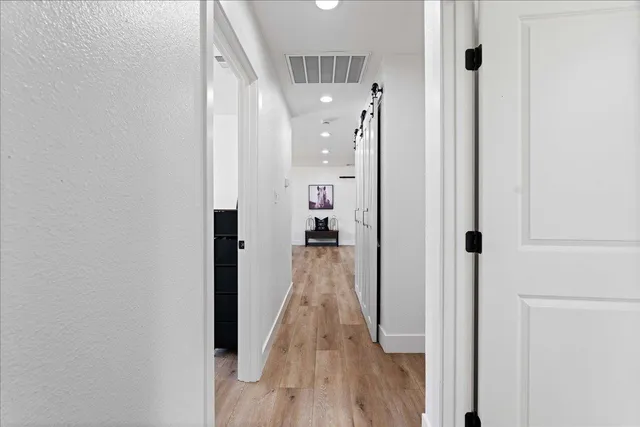a view of a hallway with wooden floor and staircase
