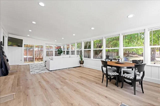 a view of a dining room and livingroom with furniture wooden floor and a rug