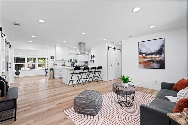 a living room with furniture and a view of kitchen