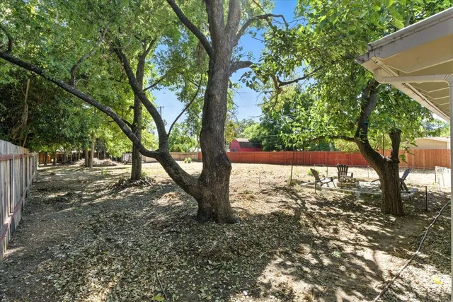 a view of a small yard with wooden floor and fence
