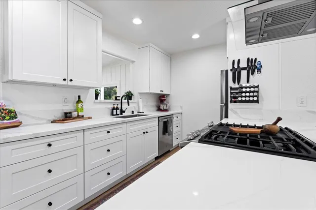 a kitchen with granite countertop white cabinets and white appliances