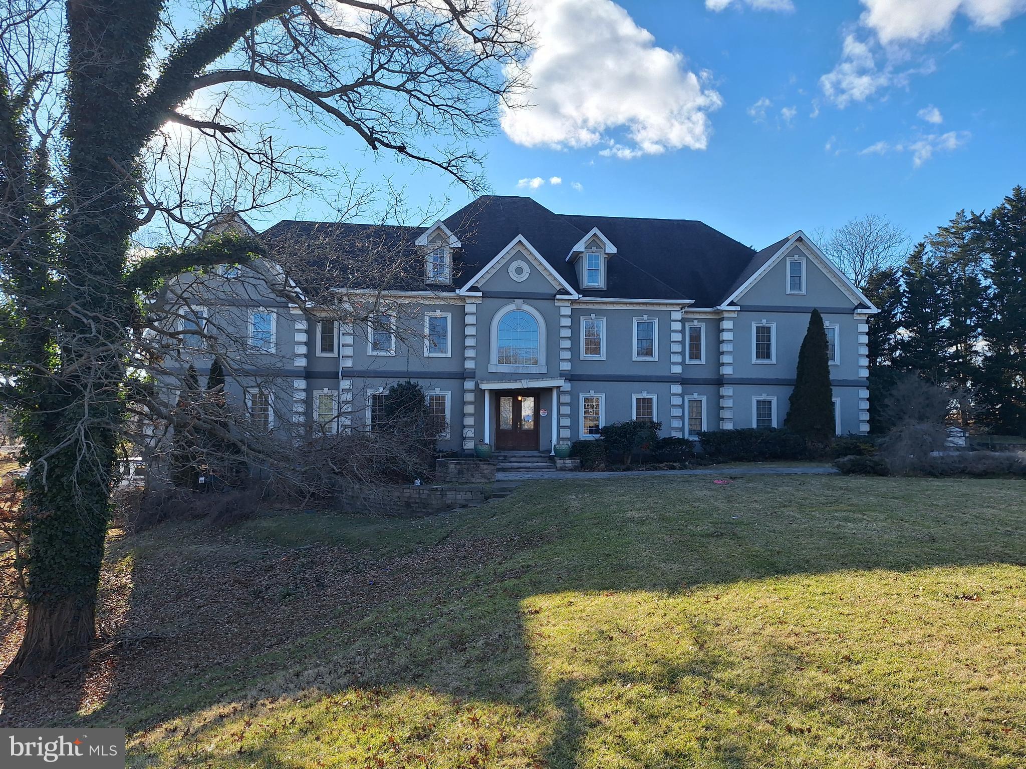 a view of a big house with a big yard and large tree
