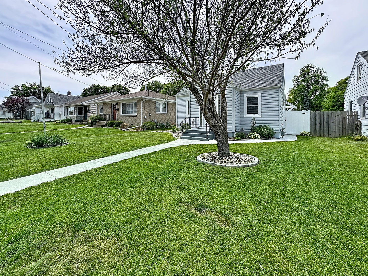 1841 32nd Street Moline, IL 61265 - Photo 3 of 24 a front view of a house with a garden and trees