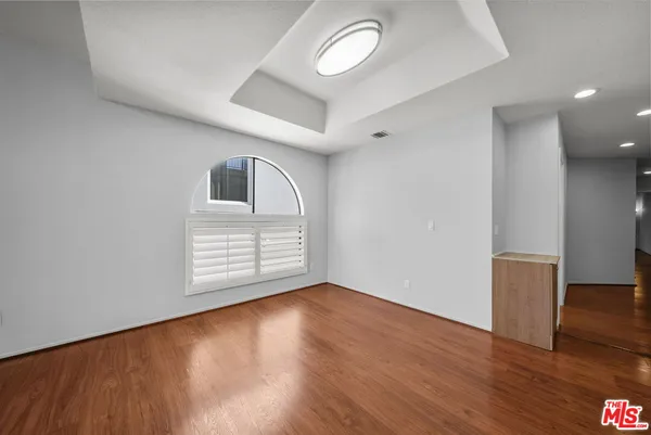 a view of empty room with wooden floor and fireplace
