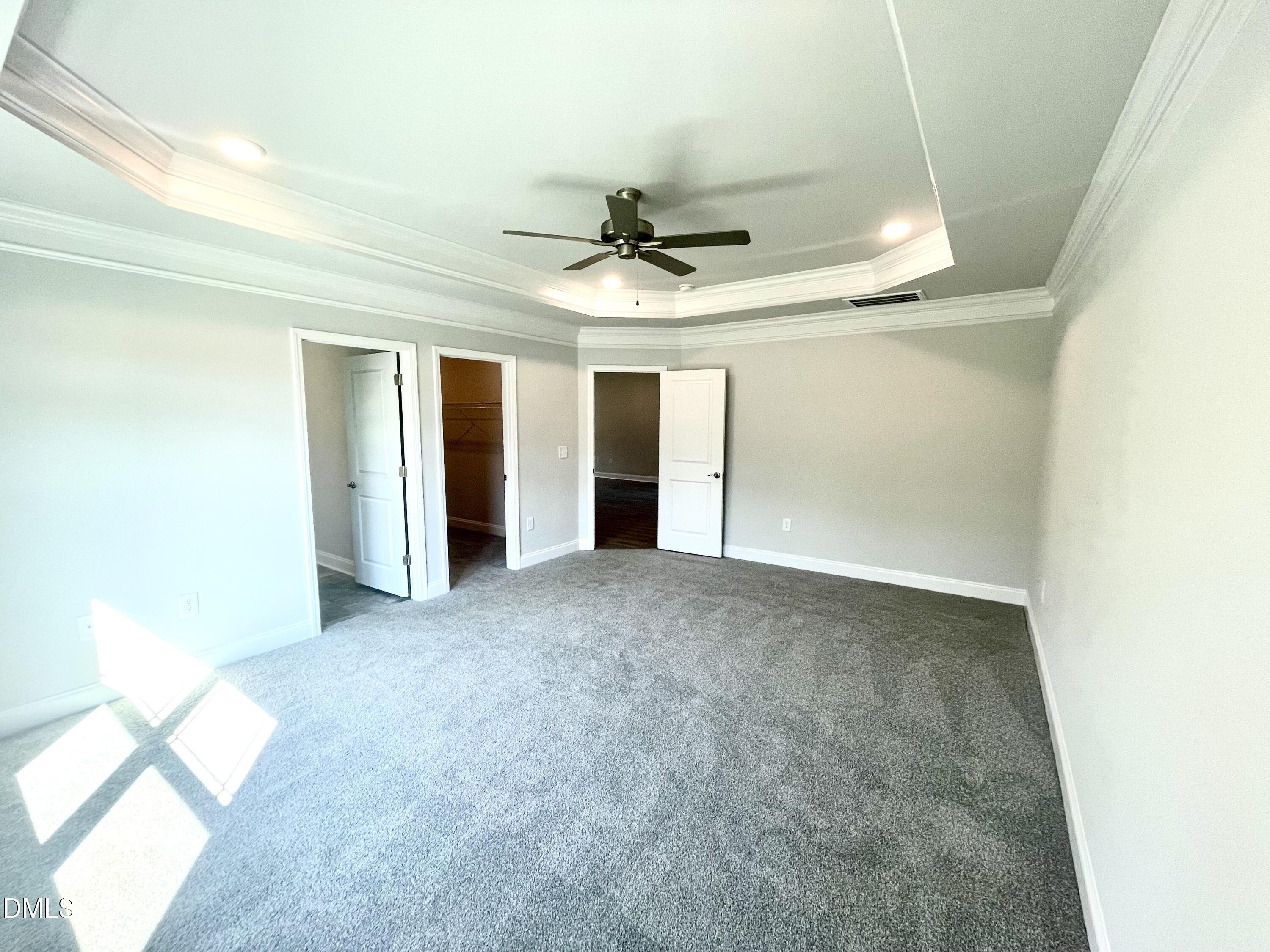 39 Deep Blue Trail Middlesex, NC 27557 - Photo 12 of 37 an empty room with a chandelier fan and windows