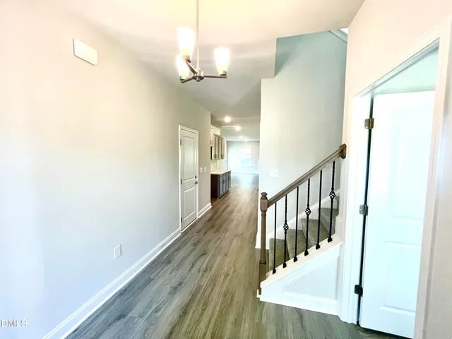 an empty room with wooden floor fireplace and windows