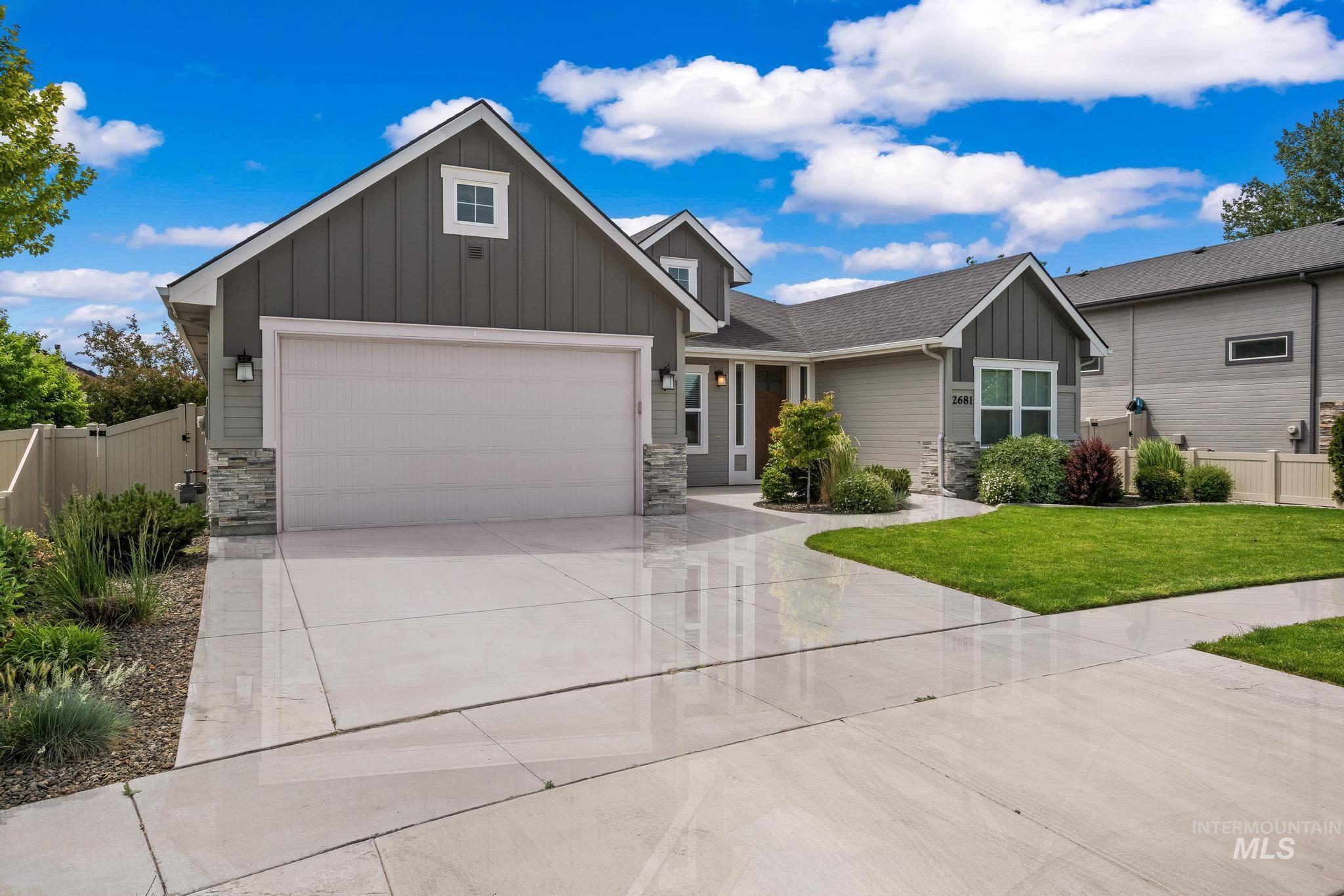 2681 East Rhyolite Court Nampa, ID 83686 - Photo 2 of 48 Contemporary exterior featuring board and batten siding, stone accents, a two-car garage, manicured landscaping, and a concrete driveway