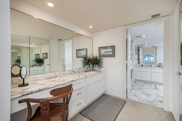 a spacious bathroom with a granite countertop sink a mirror and shower