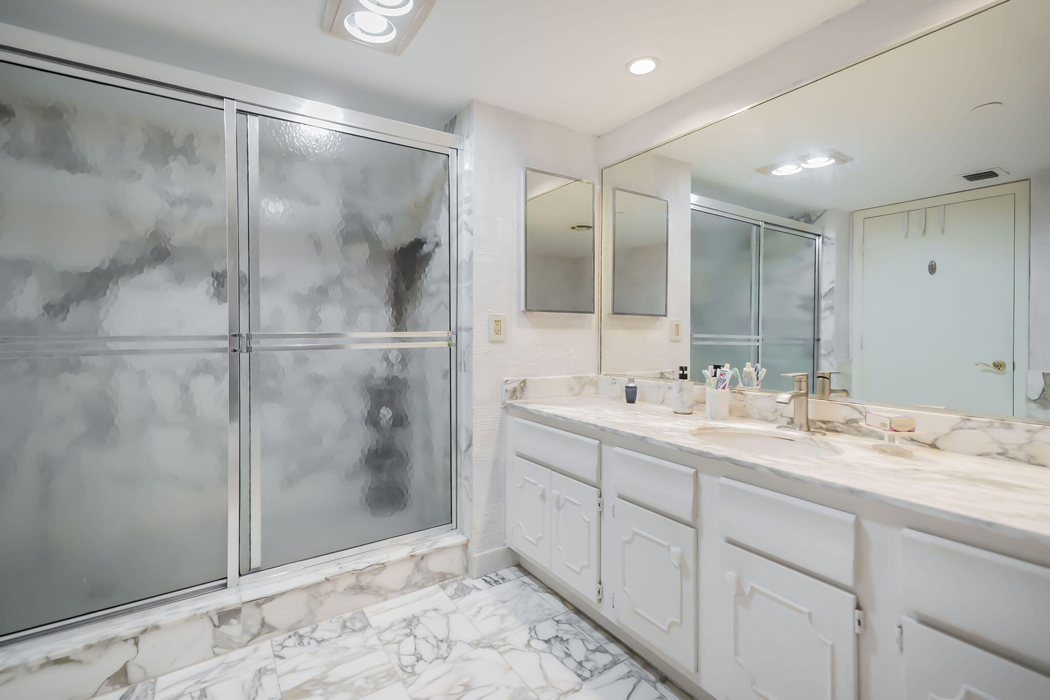 4301 North Ocean Boulevard, Unit A206 Boca Raton, FL 33431 - Photo 19 of 37 a bathroom with a double vanity sink mirror and shower
