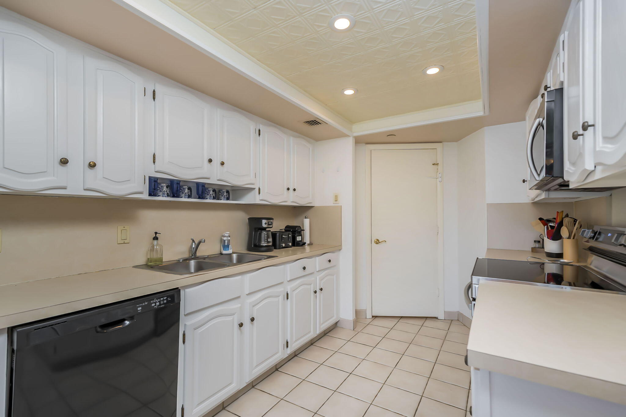 4301 North Ocean Boulevard, Unit A206 Boca Raton, FL 33431 - Photo 6 of 37 a kitchen with white cabinets and white appliances