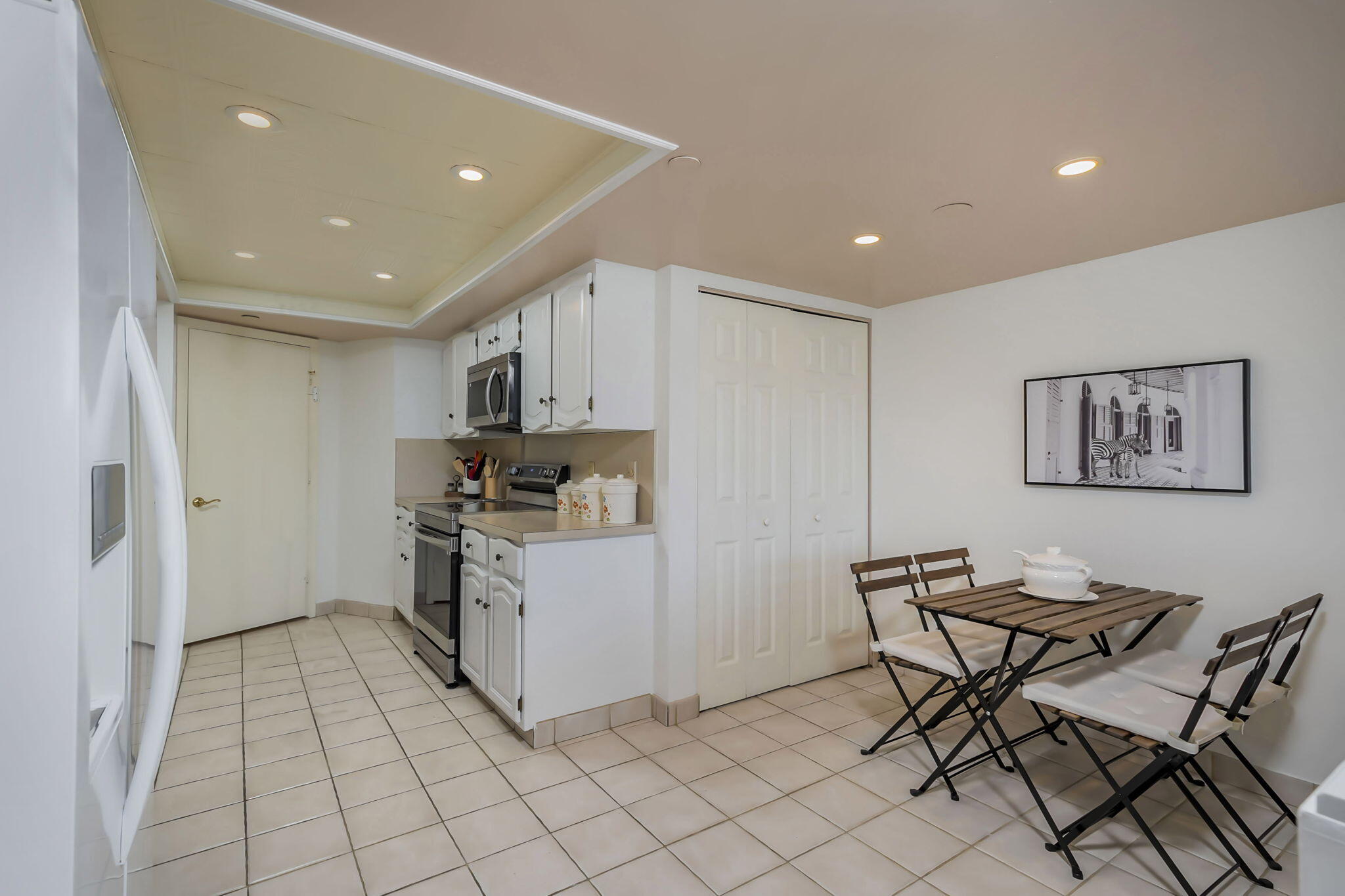 4301 North Ocean Boulevard, Unit A206 Boca Raton, FL 33431 - Photo 7 of 37 a kitchen with cabinets and chairs