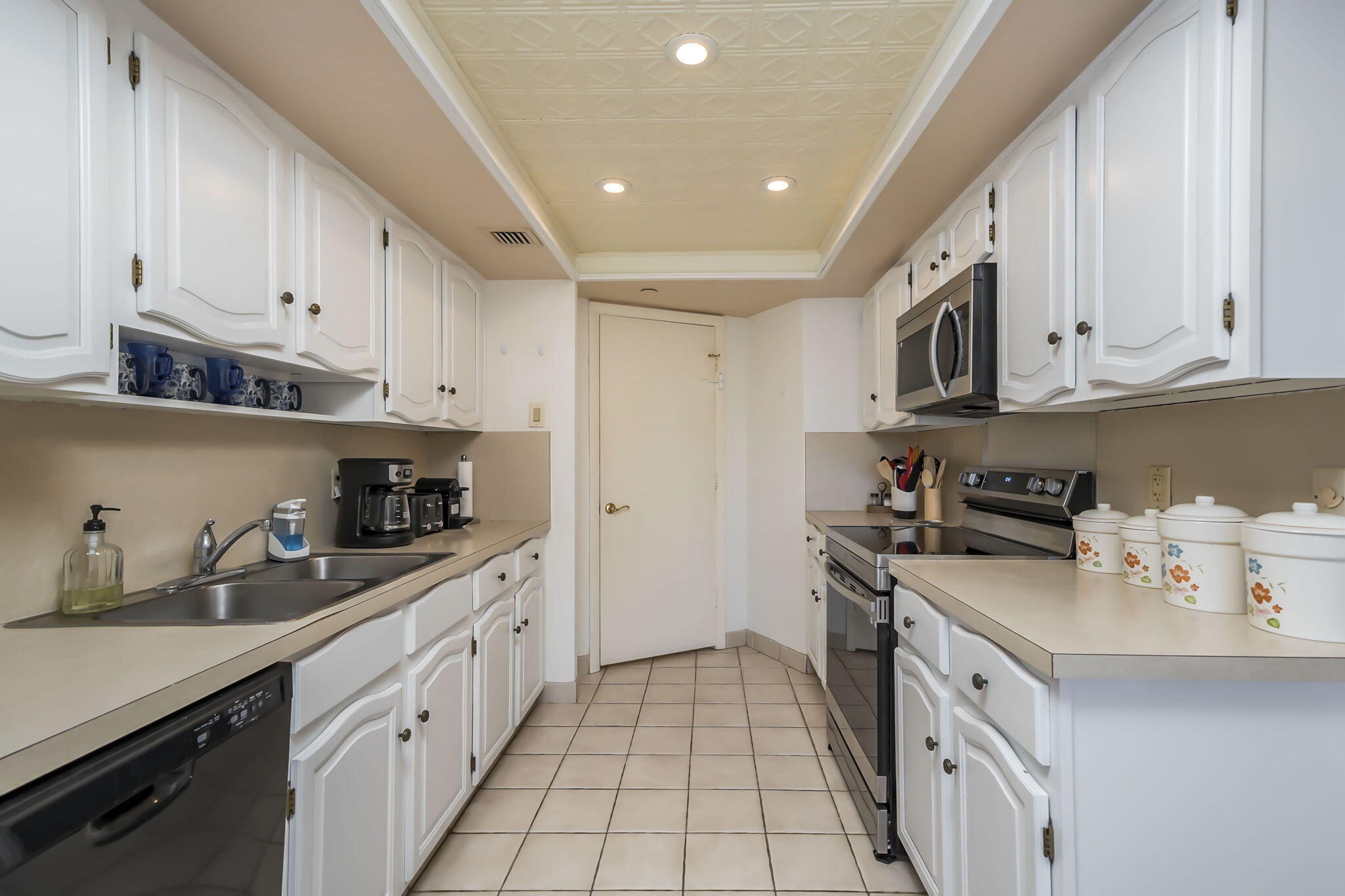 4301 North Ocean Boulevard, Unit A206 Boca Raton, FL 33431 - Photo 9 of 37 a kitchen with stainless steel appliances granite countertop a sink stove oven and white cabinets