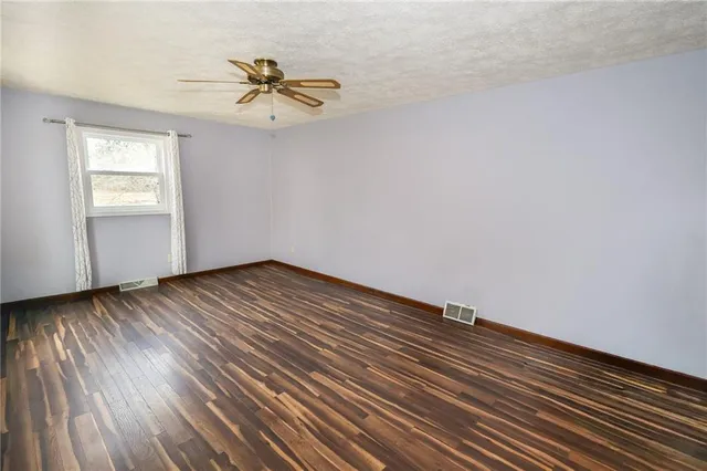 a view of a room with wooden floor and a window