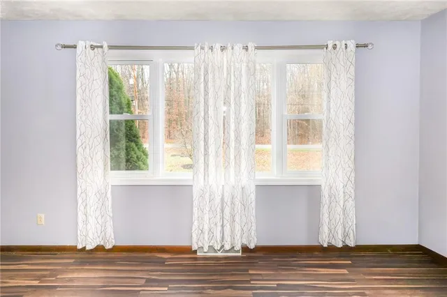 a view of a livingroom with wooden floor and a window