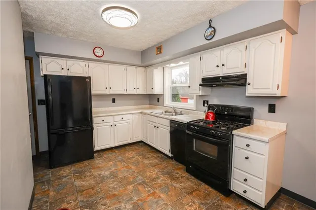 a kitchen with stainless steel appliances and white cabinets