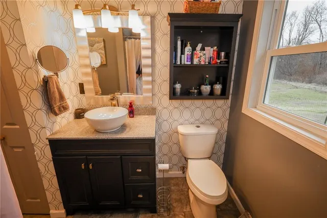 a bathroom with a toilet a sink and a window