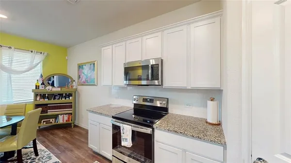 a kitchen with stainless steel appliances granite countertop a stove and a microwave