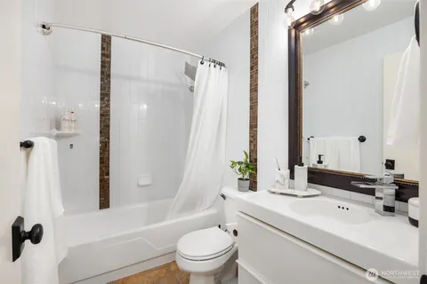 a bathroom with a sink a toilet a mirror and a shower