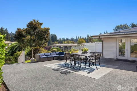 a view of a roof deck with table and chairs and a barbeque