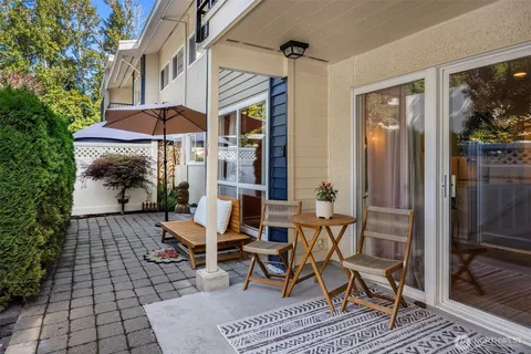 a view of a patio with table and chairs under an umbrella