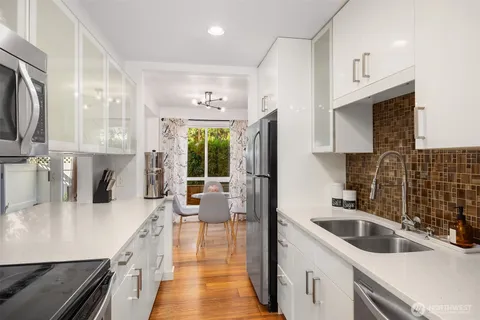 a kitchen with stainless steel appliances a sink a stove and a refrigerator