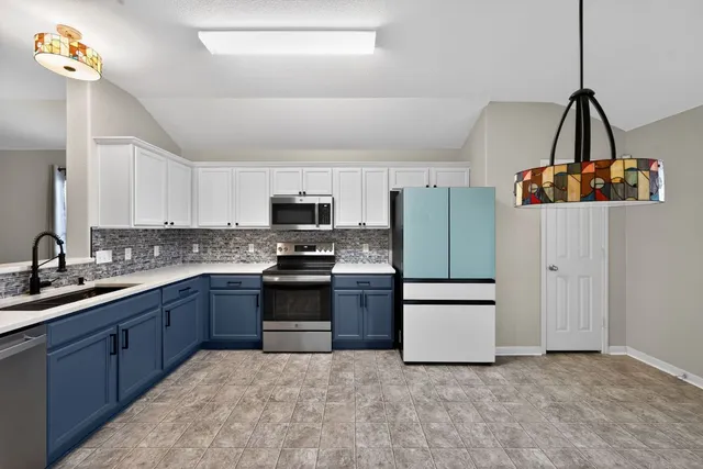 a kitchen with stainless steel appliances a stove a sink and a refrigerator