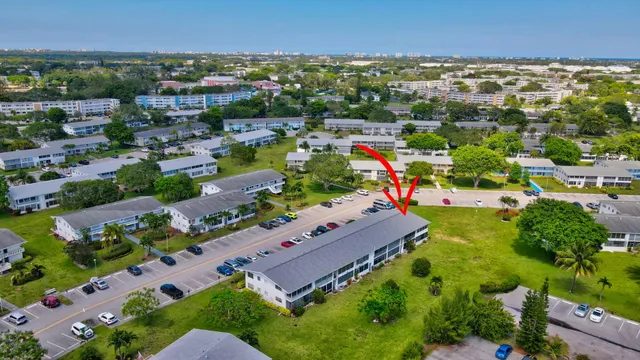 a living room with stainless steel appliances furniture a large window and a bookshelf
