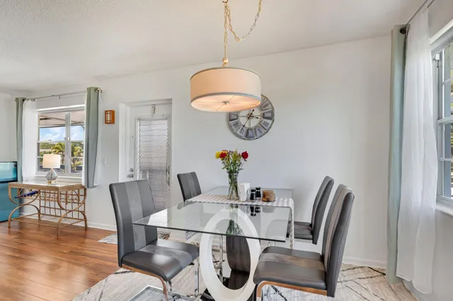 a dining room with furniture a chandelier and wooden floor