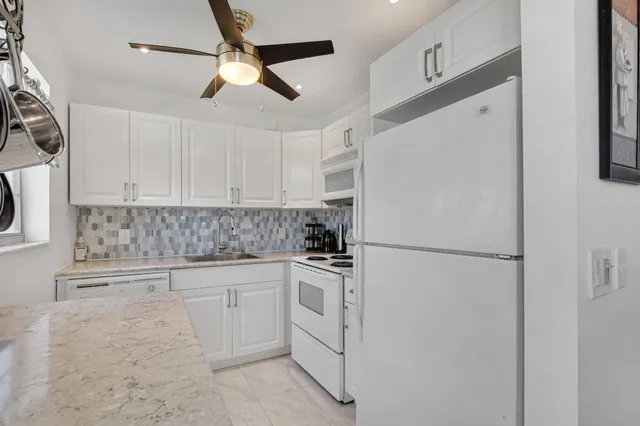 a bathroom with a granite countertop sink a toilet and a mirror