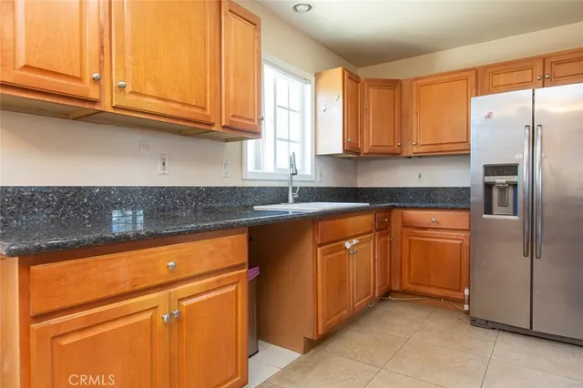 a kitchen with stainless steel appliances granite countertop a refrigerator and a sink
