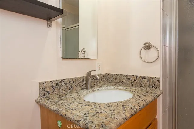 a bathroom with a granite countertop sink and a mirror