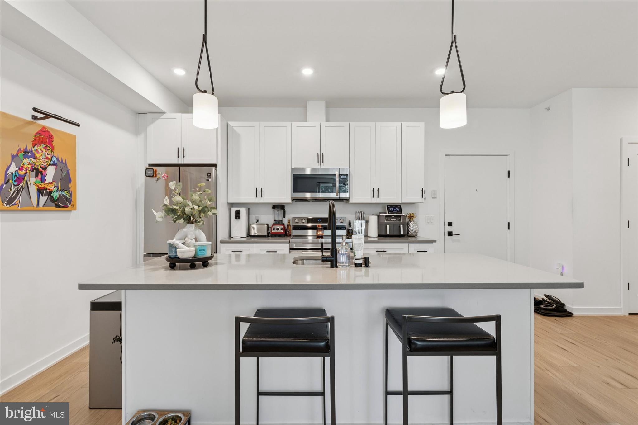 22 East Rittenhouse Street Philadelphia, PA 19144 - Photo 6 of 34 a kitchen with stainless steel appliances granite countertop a sink a stove a refrigerator and island with wooden floor