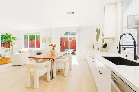 a large white kitchen with a table and chairs