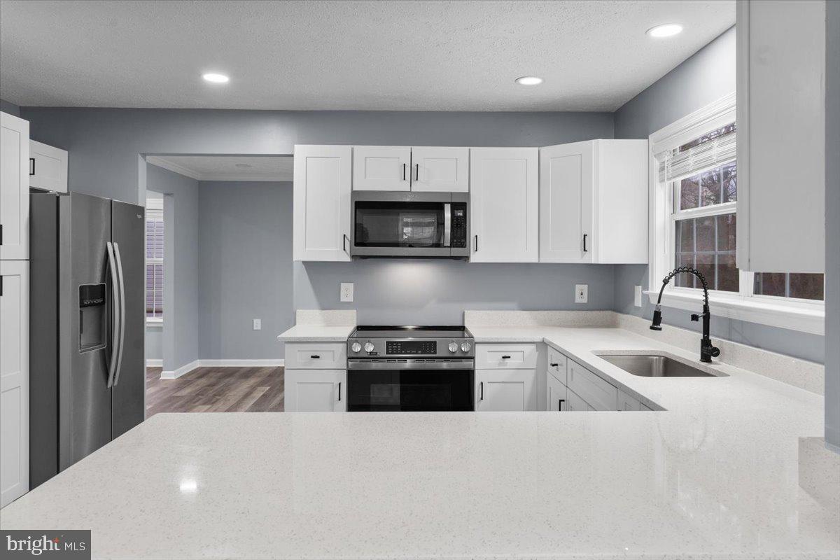 10415 Labrador Loop Manassas, VA 20112 - Photo 36 of 66 a kitchen with granite countertop a refrigerator sink and stove