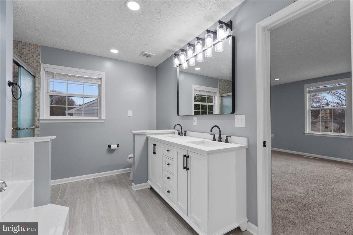 10415 Labrador Loop Manassas, VA 20112 - Photo 44 of 66 a spacious bathroom with a double vanity sink a mirror and a shower