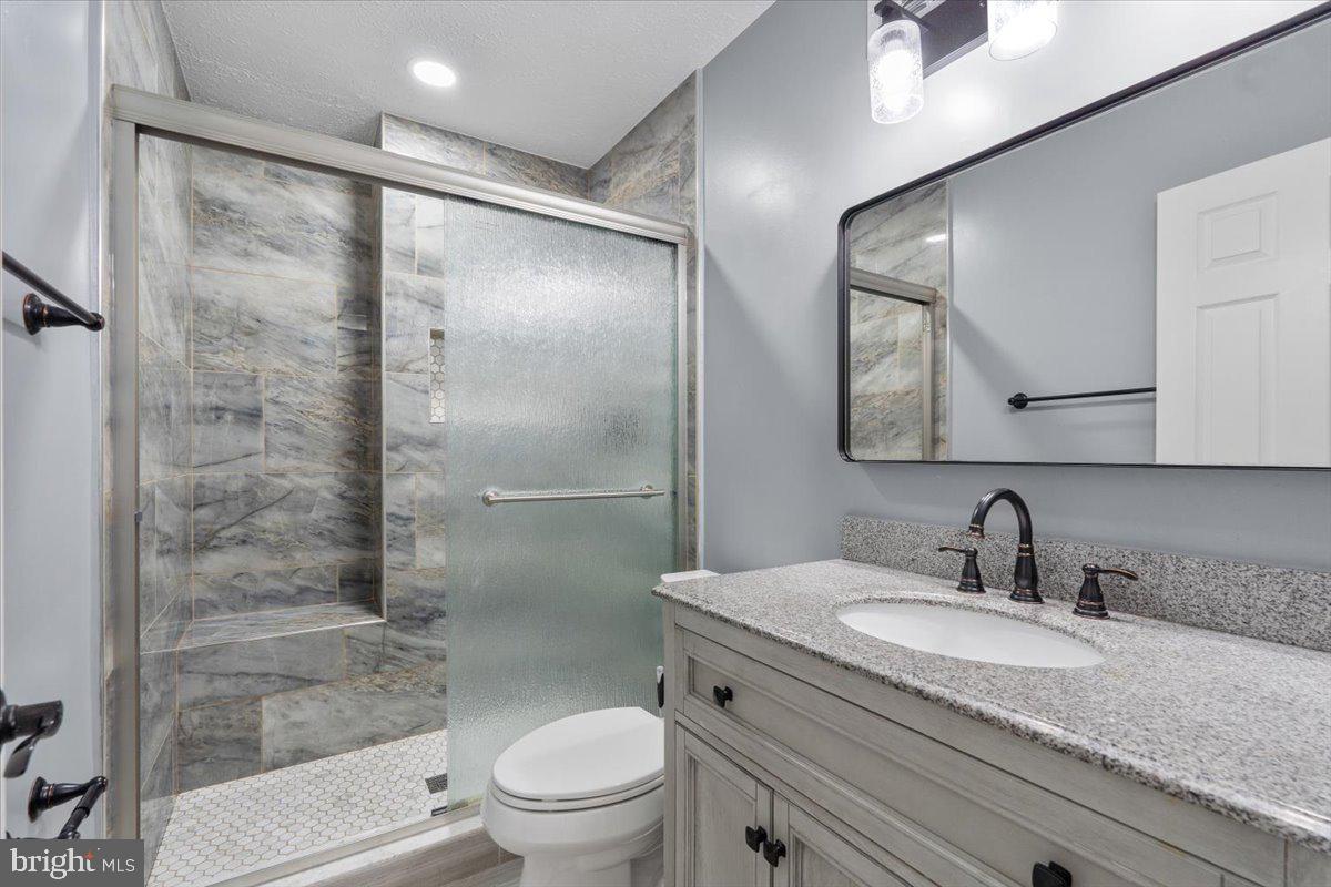 10415 Labrador Loop Manassas, VA 20112 - Photo 48 of 66 a bathroom with a granite countertop sink toilet and shower