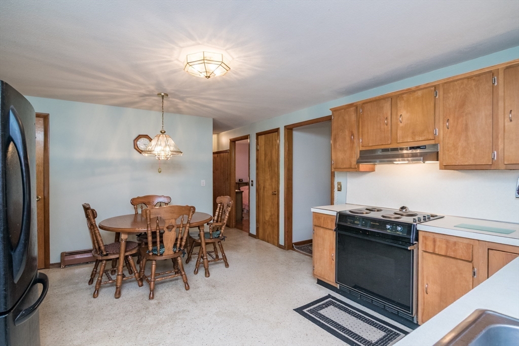 195 Mildred Avenue Springfield, MA 01104 - Photo 15 of 32 a kitchen with stainless steel appliances a table chairs and chandelier